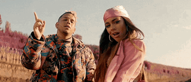 a man and woman are standing next to each other in a field .