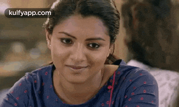 a close up of a woman 's face with a blue shirt on .