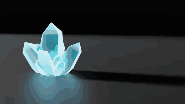 a blue crystal is sitting on a dark surface