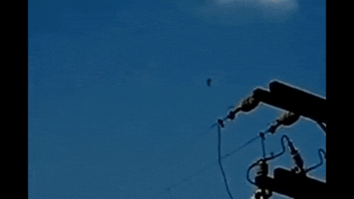 a person is hanging from a wire in the sky