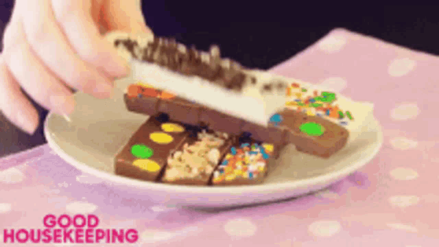 a person is holding a piece of chocolate on a plate that says good housekeeping on the bottom