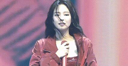 a woman is singing into a microphone on a stage .