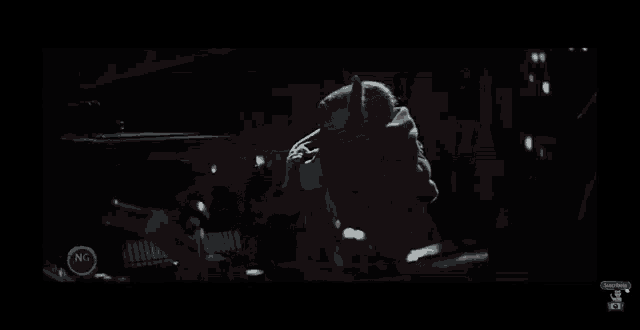 a baby yoda is being held by a man in a dark room