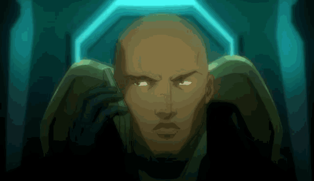 a bald man talking on a cell phone with a blue light behind him