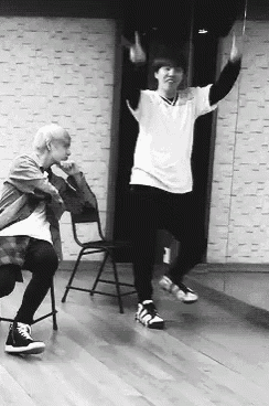 a black and white photo of two men dancing together in a dance studio .