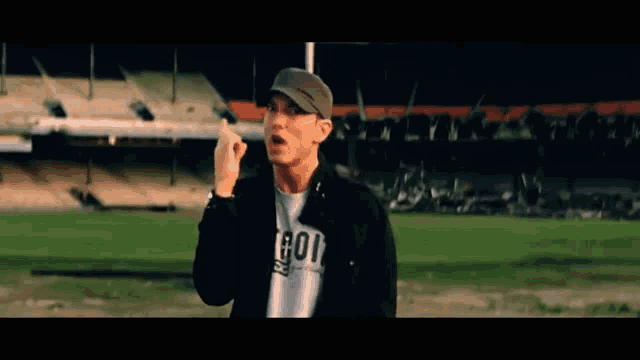 a man wearing a hat and a shirt that says got is standing on a field