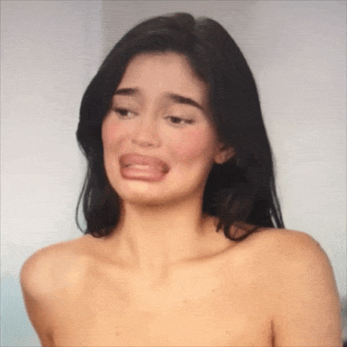 a woman without a shirt is making a funny face with her tongue out