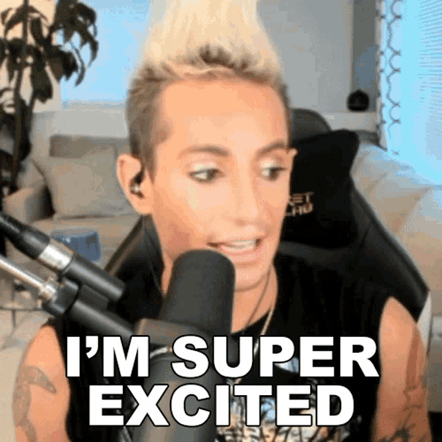 a man sitting in front of a microphone with the words i 'm super excited above him