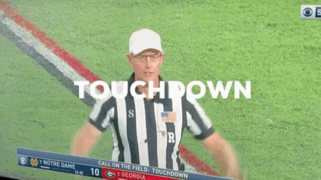 a referee stands in front of a screen that says touchdown on it