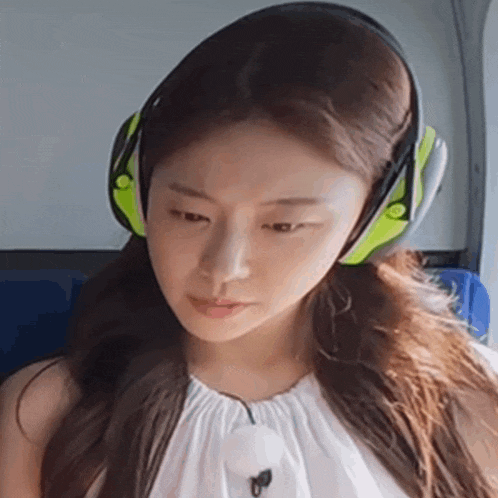 a close up of a woman wearing headphones on a bus .