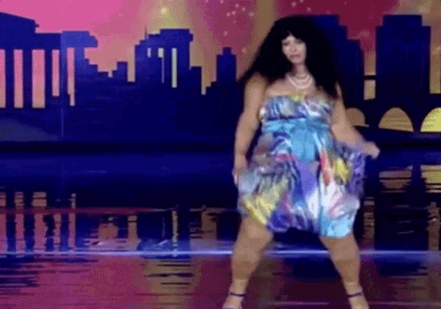 a woman in a blue dress is dancing on a stage .