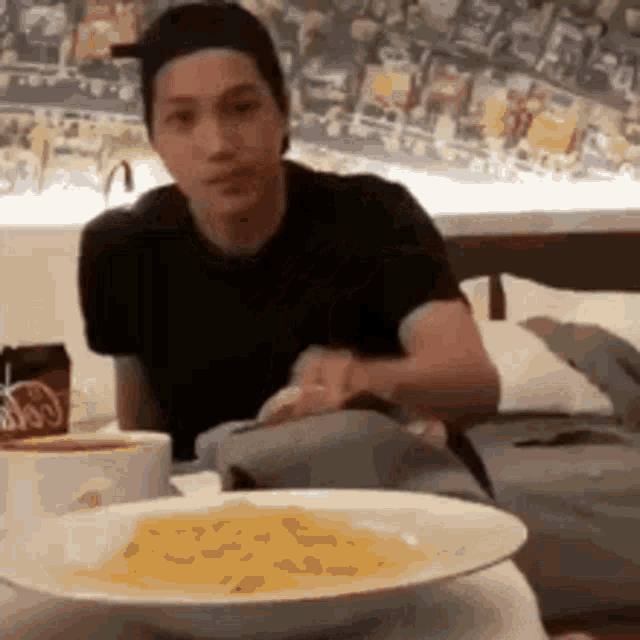 a man is sitting at a table with a plate of food .