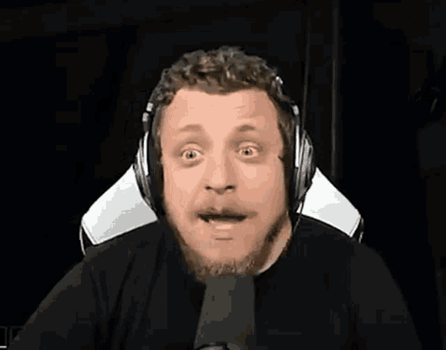 a man wearing headphones is sitting in front of a microphone and says ez mi volt ez ?