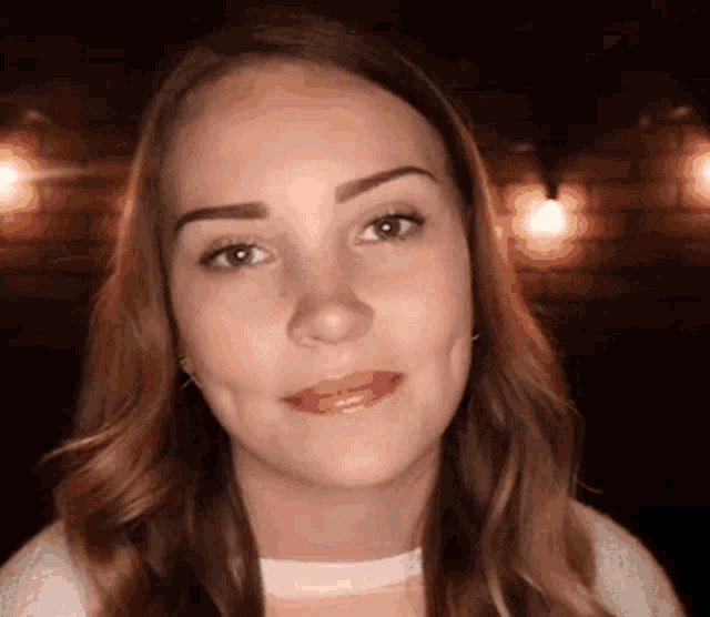 a close up of a woman 's face with a blurred background .