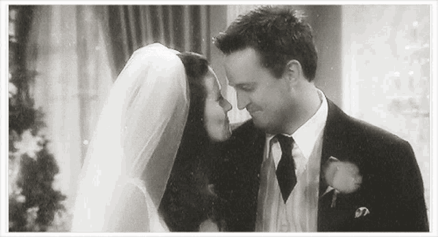 a black and white photo of a bride and groom looking at each other