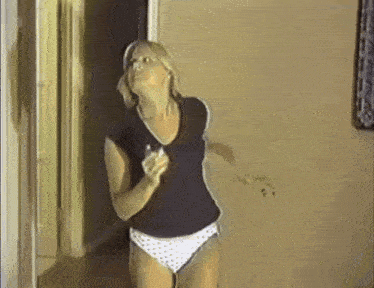 a woman in polka dot underwear stands in a hallway