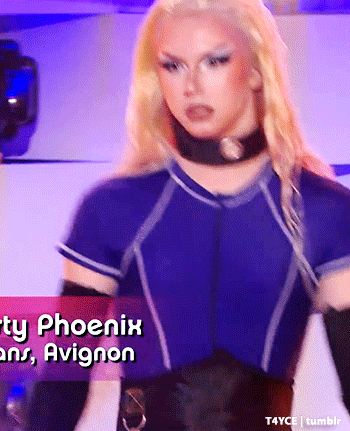 a blonde woman in a blue shirt and black gloves is standing in front of a sign that says phoenix and avignon .