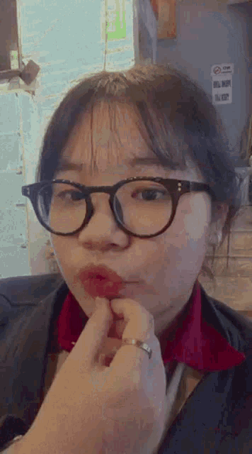 a woman wearing glasses and a red shirt is being kissed