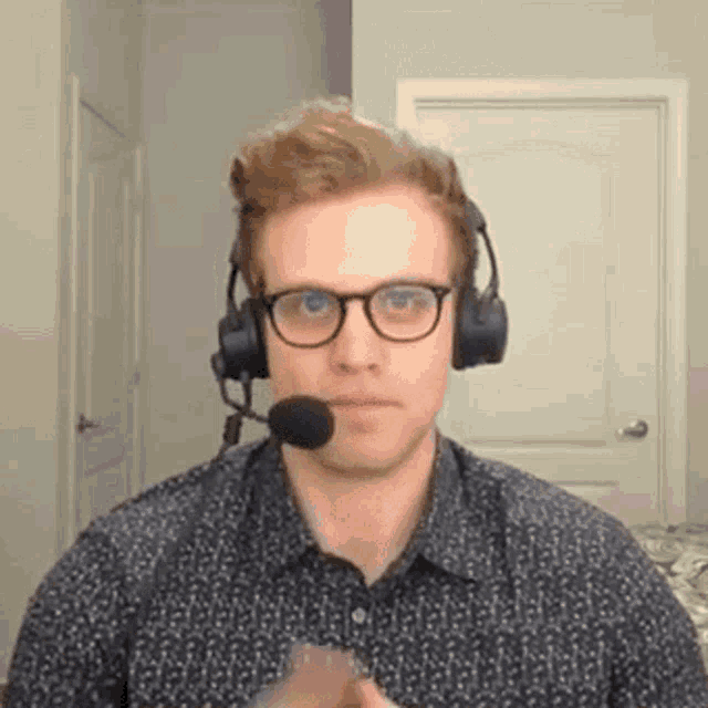a man wearing glasses and headphones with a microphone is making a funny face .