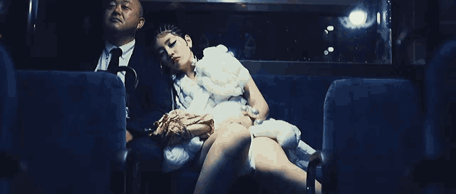 a man and a woman are sitting on a couch in a dark room