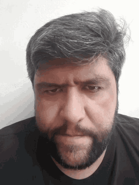 a man with gray hair and a beard is making a face