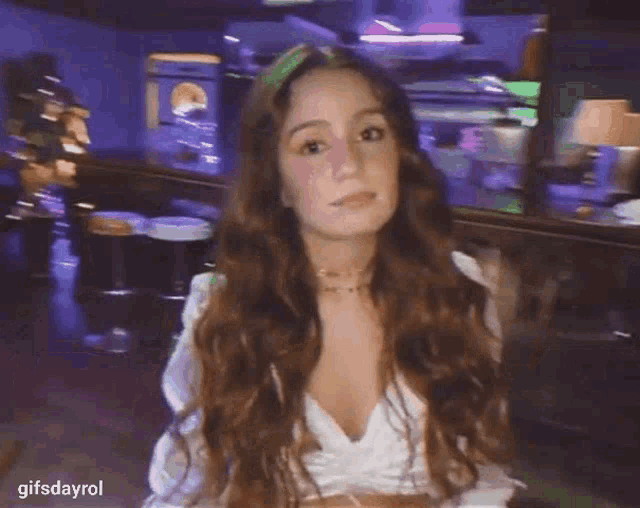 a woman with long hair is standing in front of a bar .