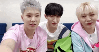a group of young men are sitting next to each other on a couch and looking at the camera .