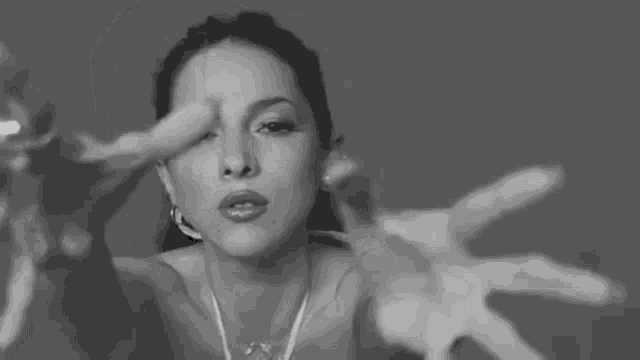 a black and white photo of a woman in a bikini making a face .