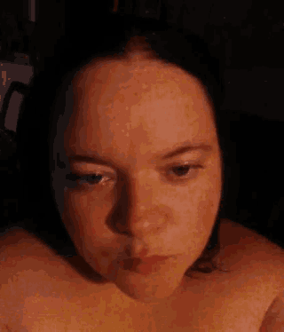 a woman without a shirt is making a kissing face