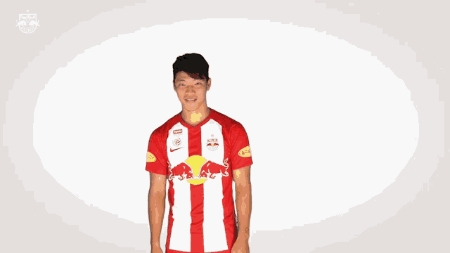 a man wearing a red and white striped shirt with a red bull on it