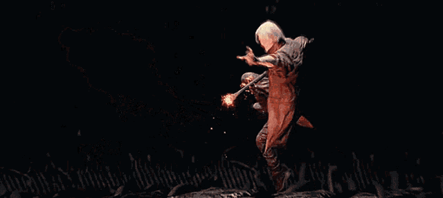 a man with a ring on his finger is holding a ball of fire