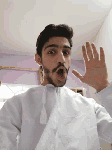 a man in a white shirt is making a funny face with his mouth open