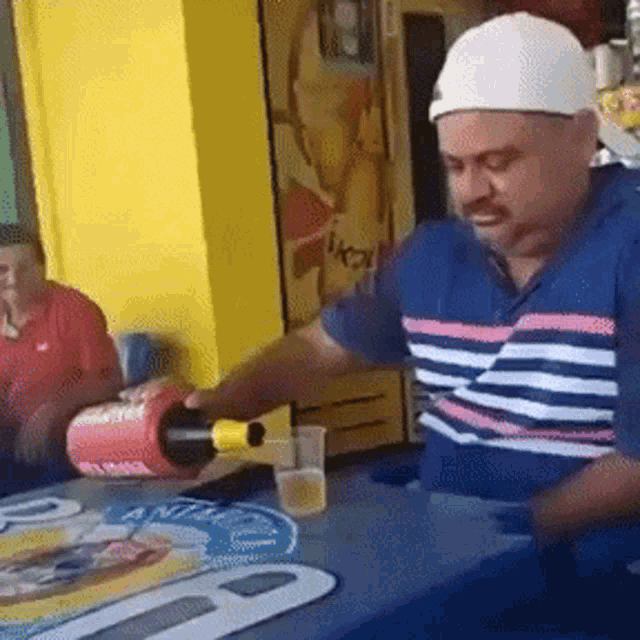 a man pouring a bottle of beer into a cup