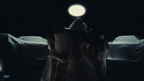 a group of women standing next to each other in front of a car