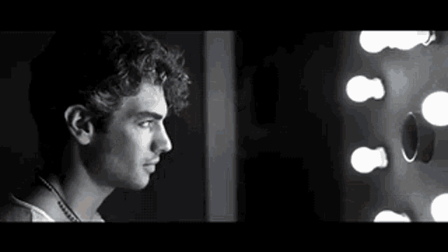 a man is looking at himself in a mirror .