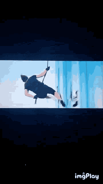 a man is hanging upside down from a rope on a television screen