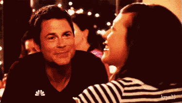 a man and a woman are sitting next to each other and smiling .