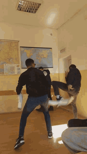 a map of the world hangs on the wall behind the people