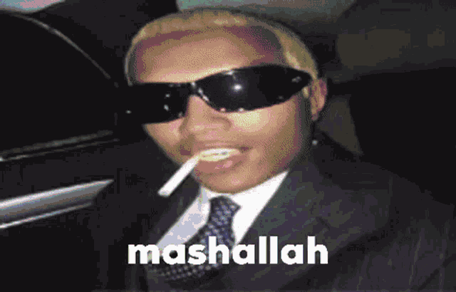 a man in a suit and tie is smoking a cigarette and has mashallah written on the bottom