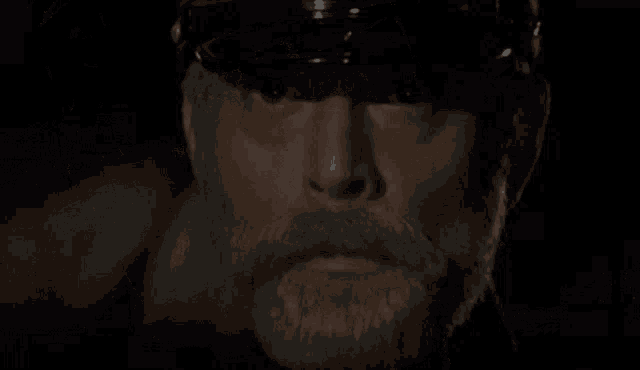 a man with a beard wearing a black hat