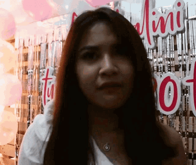 a woman stands in front of a sign that says " mini "