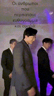 three men in suits are standing next to each other with purple lights behind them and a sign that says " οι ανδρωποι που "