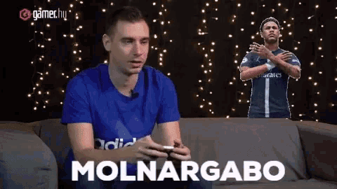 a man sitting on a couch with the words molnargabo written on the couch