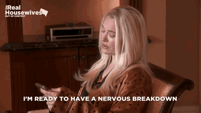 a woman sitting in a chair with a real housewives logo on the corner