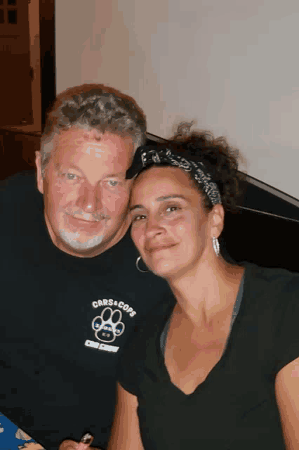 a man and a woman are posing for a picture with the man wearing a shirt that says cars & cops