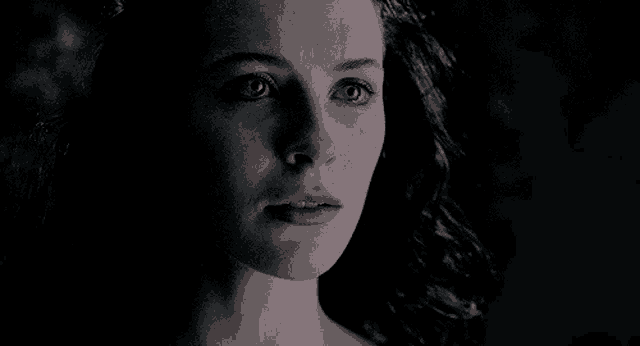 a close up of a woman with her eyes closed in the dark .