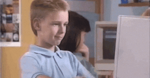 a young boy is sitting in front of a computer monitor .