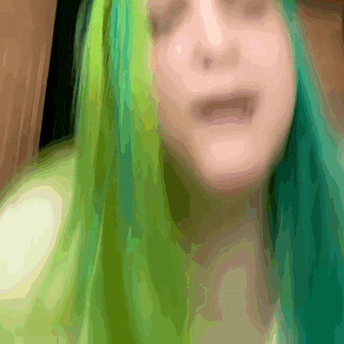 a close up of a woman with green hair