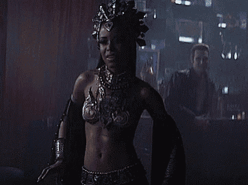 a woman with a crown on her head is standing in a dark room