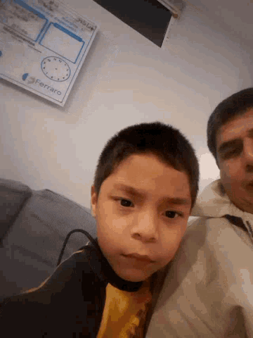 a man and a boy are posing for a picture in front of a calendar that says ' marzo ' on it